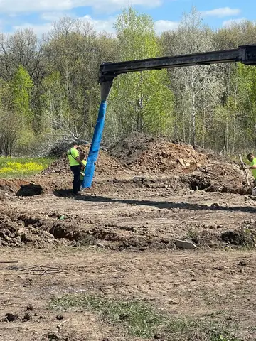 Worker using a concrete pump at a construction site in Gilman