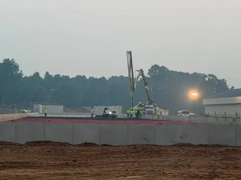 Construction team pouring concrete on a foggy morning in Gilman