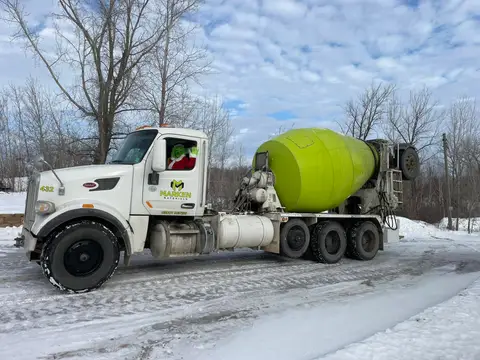 Concrete mixer truck driving on a snowy road in Gilman, MN
